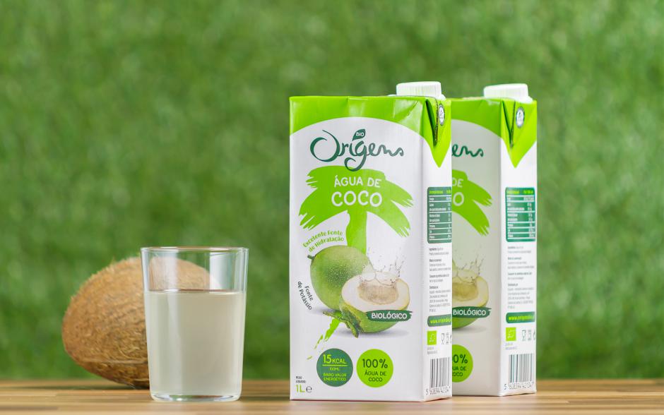 Duas embalagens e um copo de água de coco Origens Bio